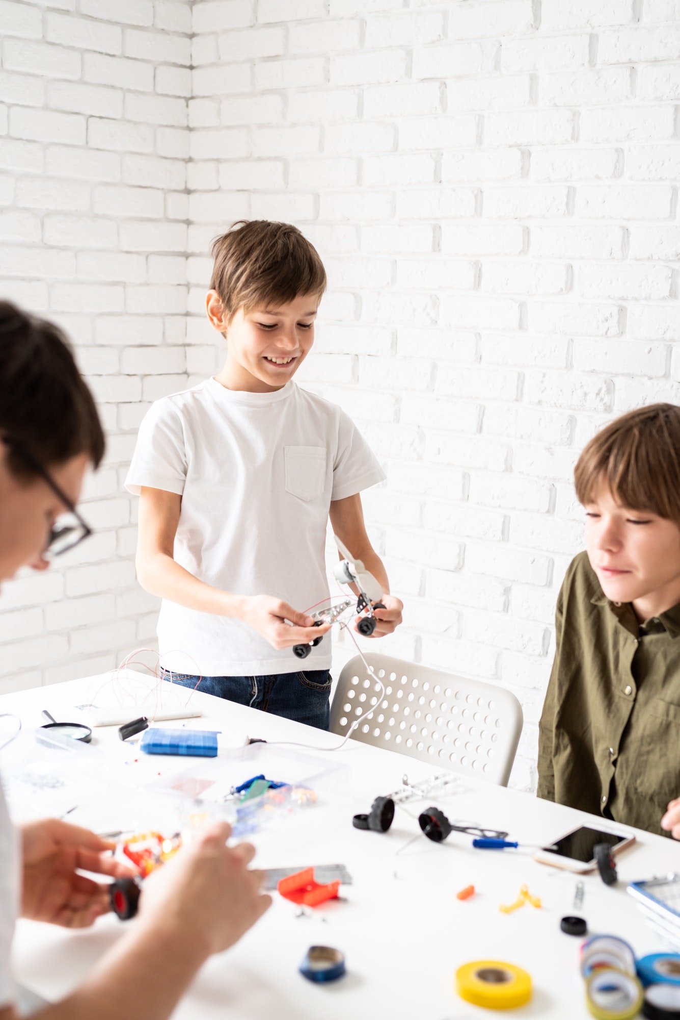 Young boys having fun constructing robot cars at the workshop